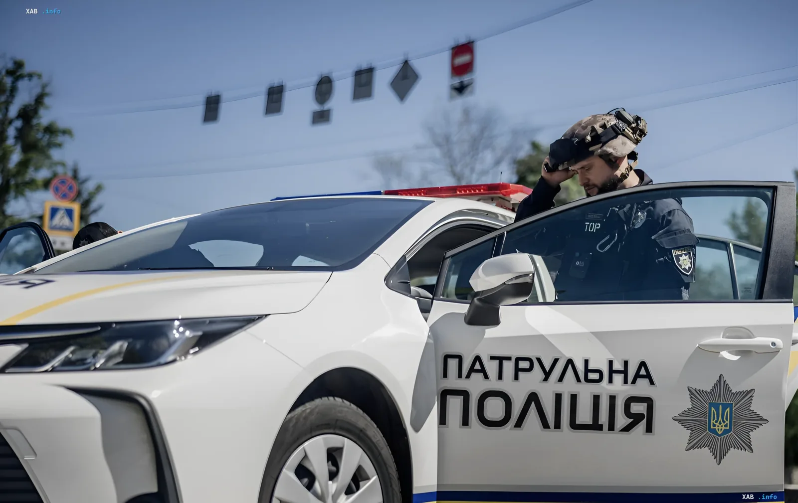 Полицейский патрульной полиции Украины у служебного автомобиля на фоне инцидента во Львове: задержание участников нападения на военных