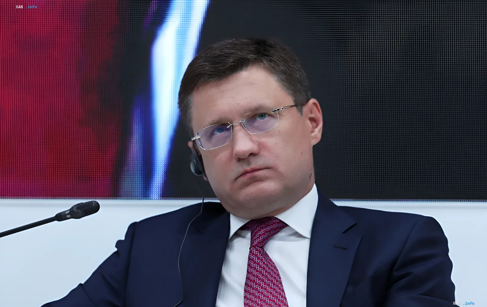 Alexei Nowak, russischer Energieminister, vor einem Bildschirm mit Grafiken, diskutiert die Treibstoffkrise und den Einfluss von Drohnenangriffen auf Raffinerien.
