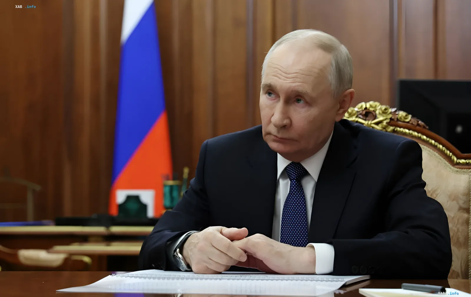 Wladimir Putin am Schreibtisch in einem Büro mit russischer Flagge im Hintergrund, nachdenklich über die Auswirkungen von Angriffen auf Raffinerien auf die Bevölkerungszufriedenheit und sein Rating