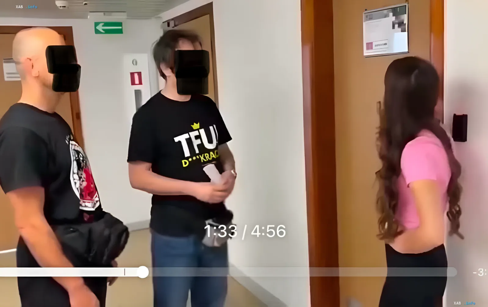 Rechtsextreme Aktivisten in Posen, festgenommen wegen Belästigung einer ukrainischen Unternehmerin, stehen im Flur vor einer Tür