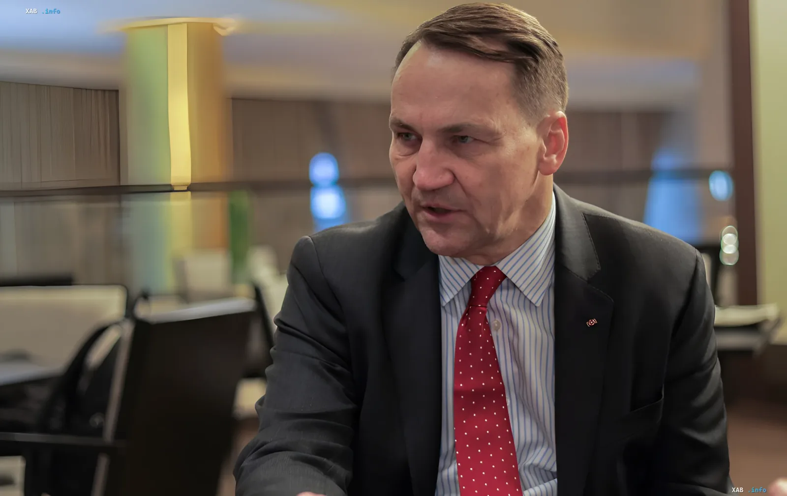 Mark Sikorsky in a business suit discusses Kremlin threats to Europe, including cyberattacks and death squads