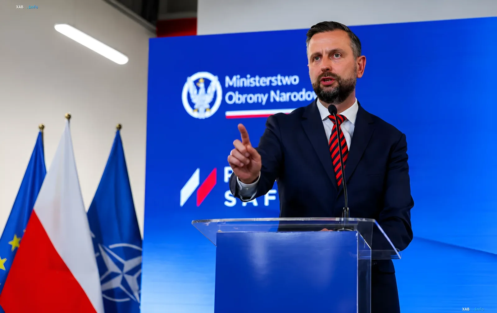 Mariusz Błaszczak, Verteidigungsminister Polens, hält eine Rede vor den Flaggen der EU und NATO und diskutiert den Konflikt mit dem Präsidenten über Raketen für die Ukraine.