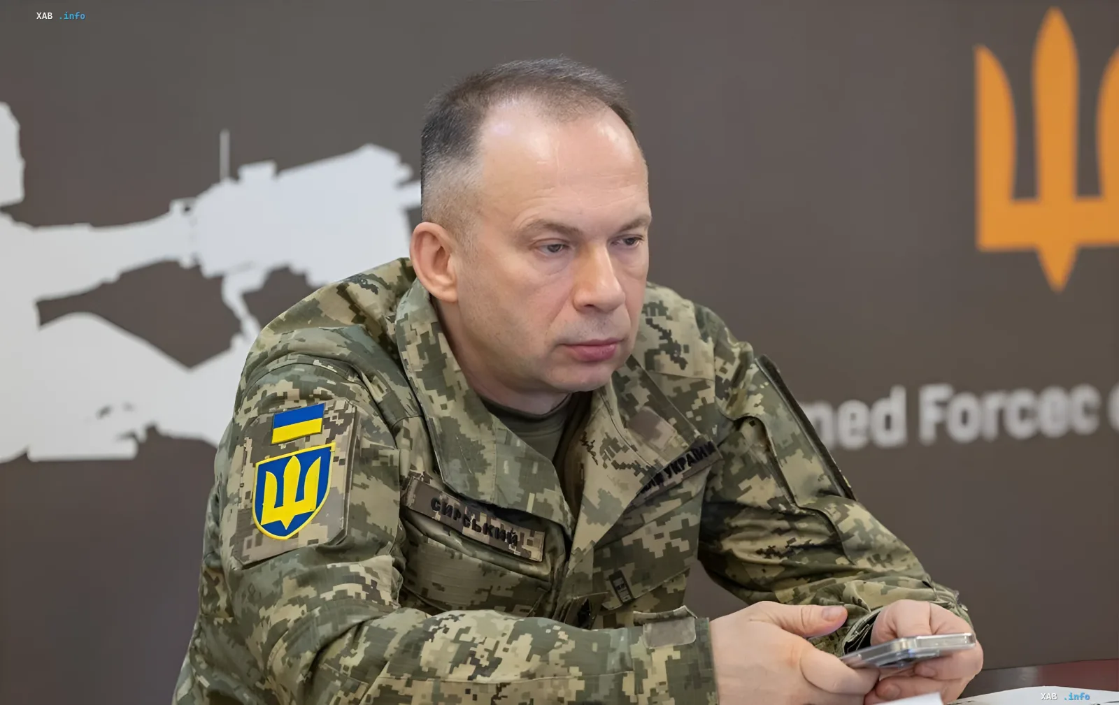 Generaloberst Oleksandr Syrskyi in Uniform vor dem Logo der Streitkräfte der Ukraine, diskutiert die strategischen Ziele Russlands und die Realität der Front