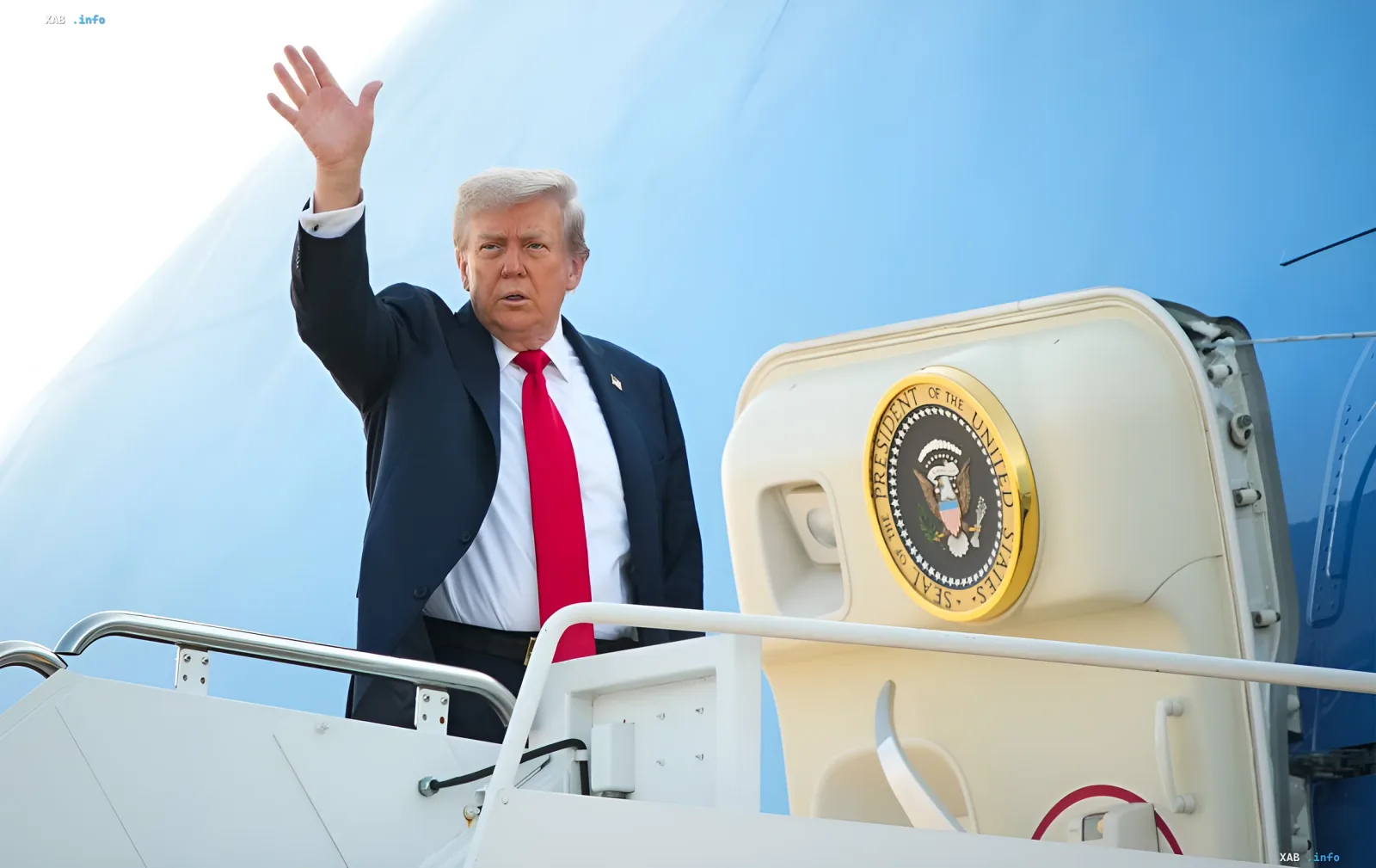 Дональд Трамп машет рукой, стоя на трапе нового самолета Air Force One с гербом Президента США на борту, в контексте расследования уязвимостей безопасности.