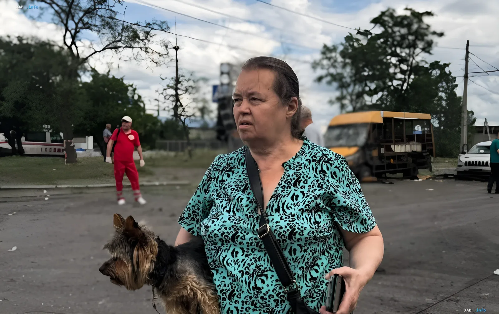 Женщина с собакой на улице после новой атаки на Сумы, где погибли четыре человека, включая ребенка