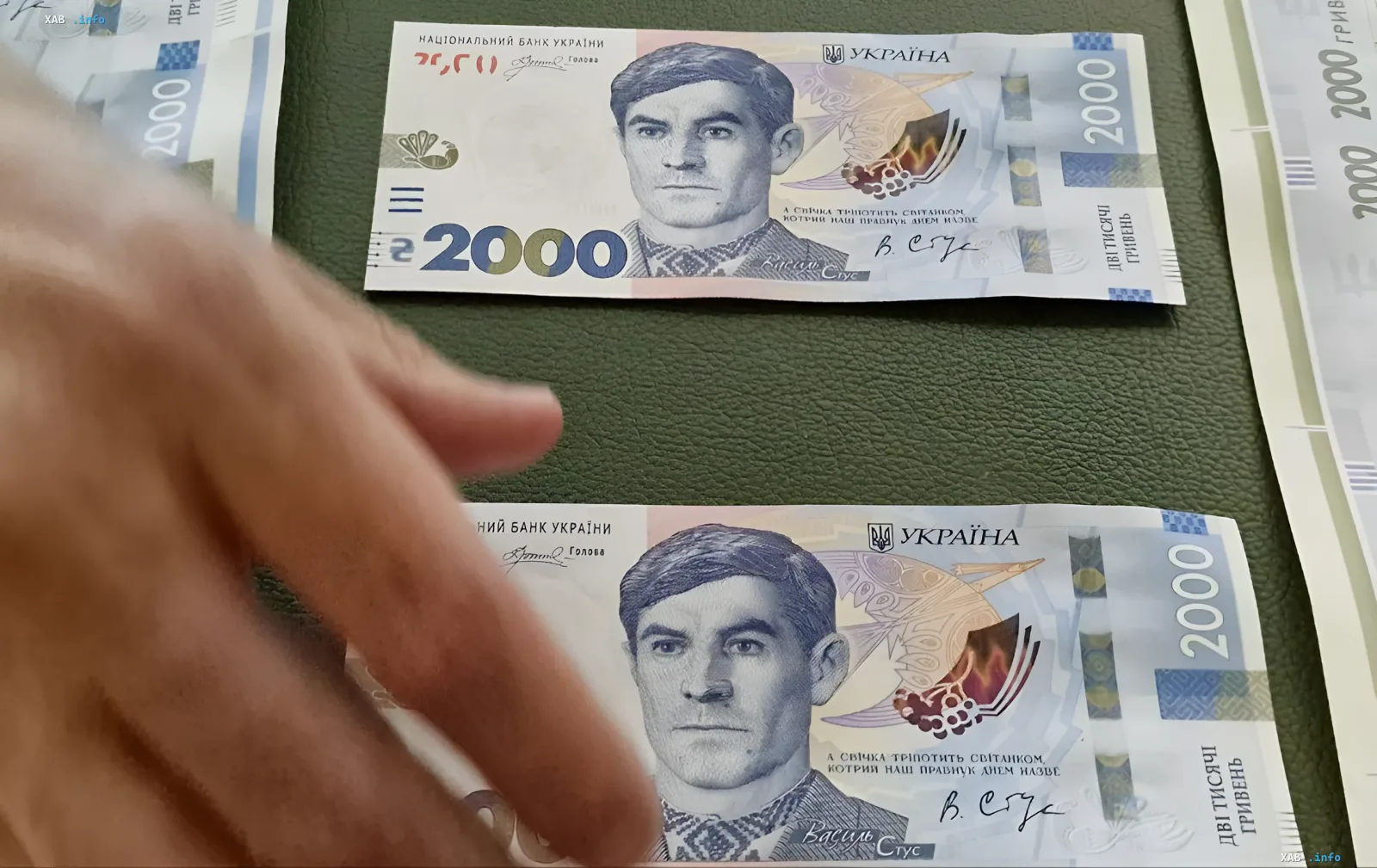 Нові купюри номіналом 2000 гривень з портретом Василя Стуса на фоні зеленого гаманця, що ілюструють тему грошової реформи в Україні