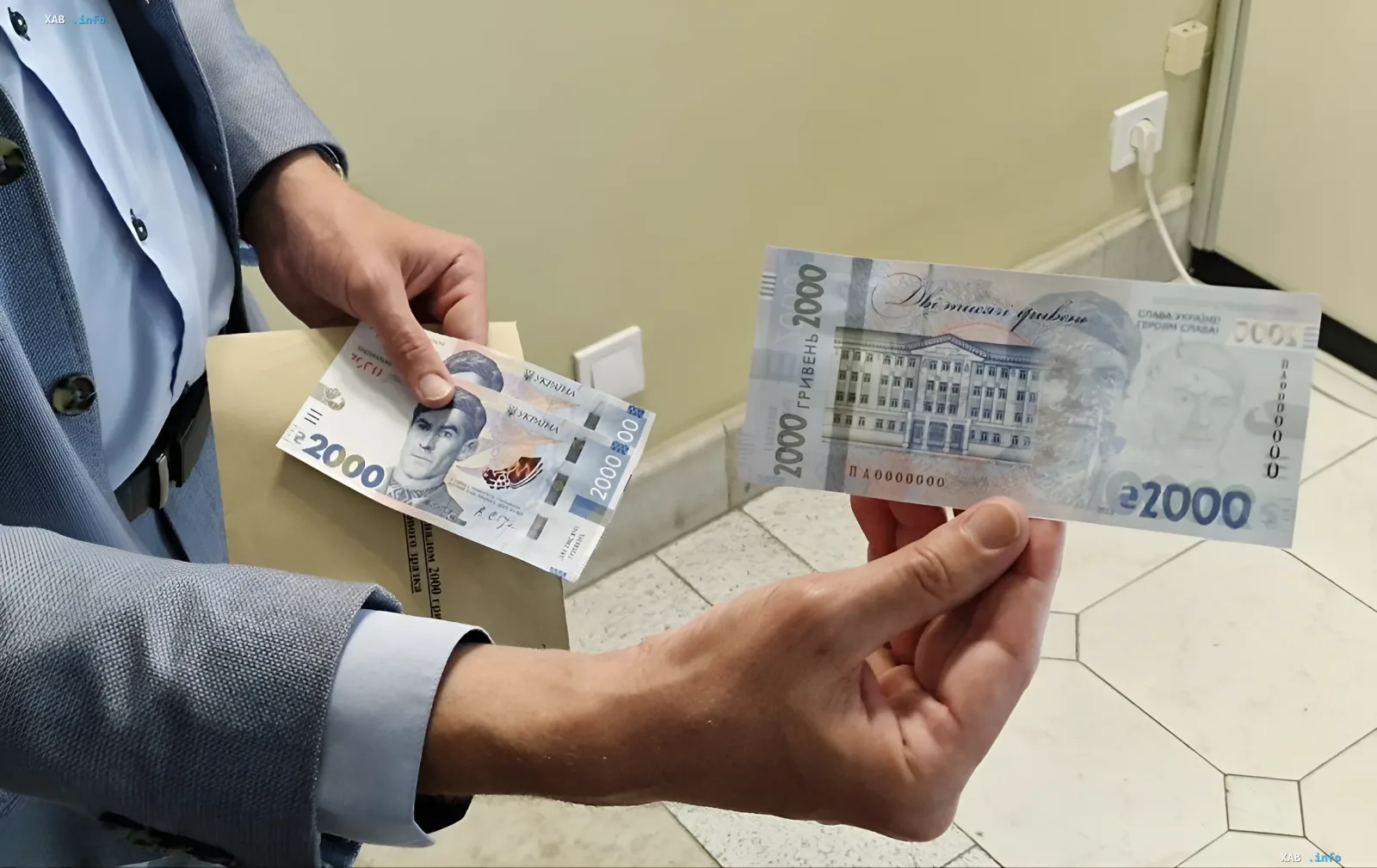Сотрудник Национального банка демонстрирует новую банкноту номиналом 2000 гривен с портретом Василия Стуса