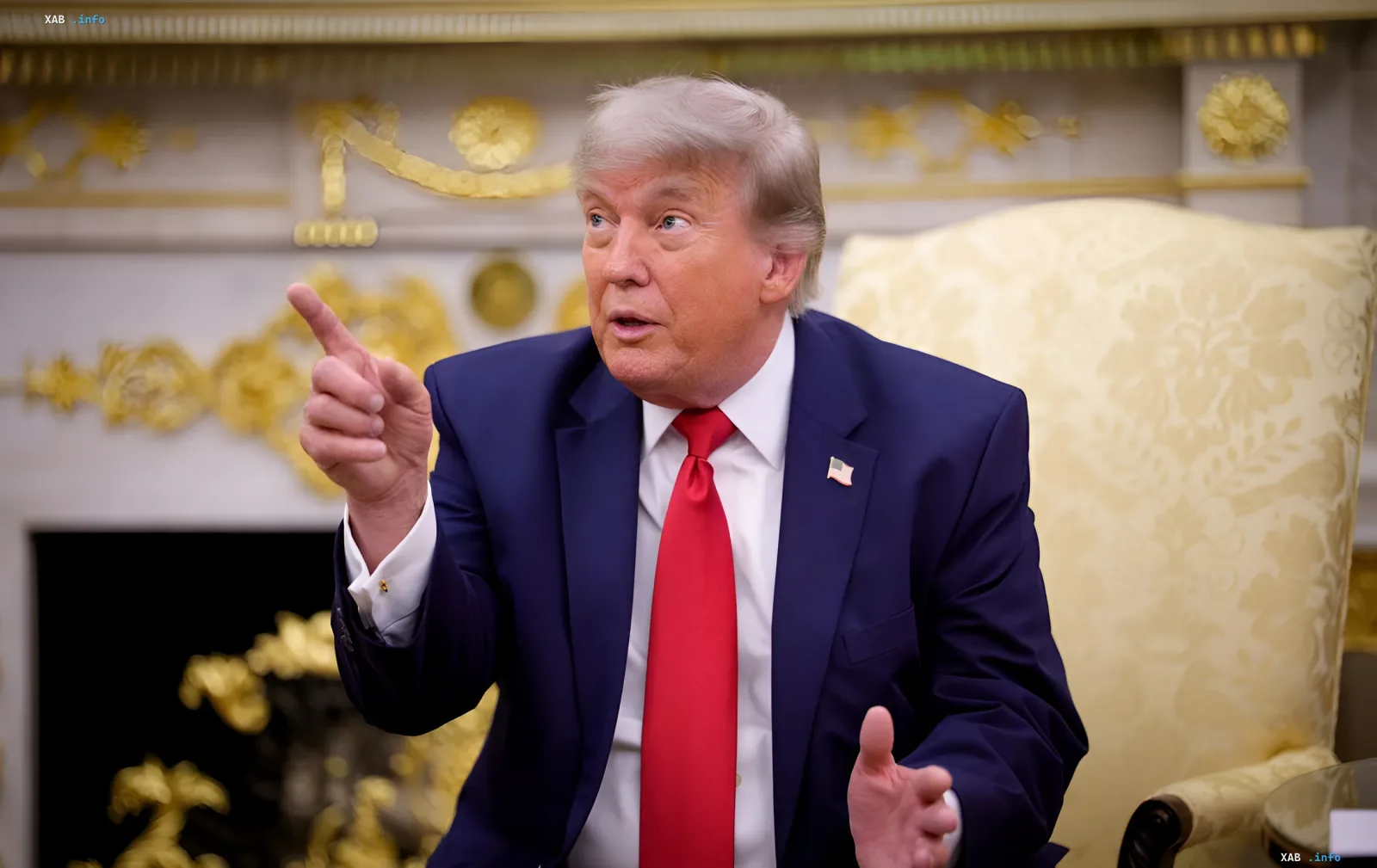Дональд Трамп в синем костюме и красном галстуке жестом указывает, предупреждая Иран о возможных последствиях