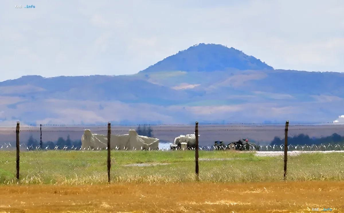 Feld mit militärischen Einrichtungen vor bergigem Hintergrund — Symbol der geopolitischen Spannungen um S-400 und F-35