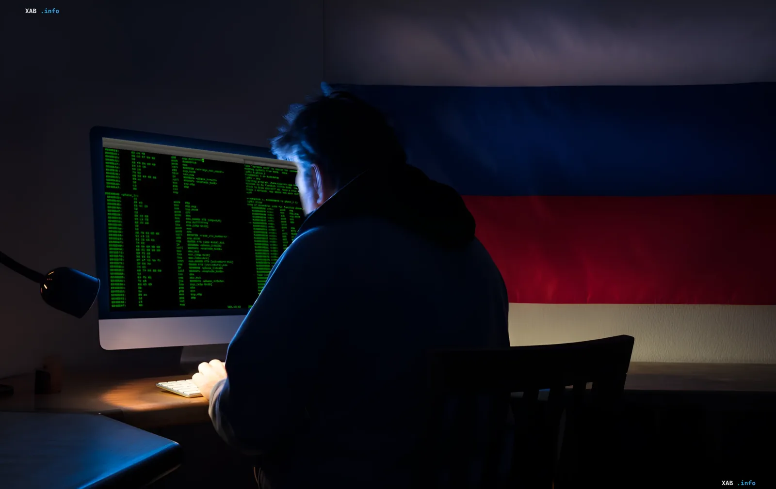 Хакер за компьютером с российским флагом на фоне, символизирующий взлом камер наблюдения для отслеживания военных поставок НАТО в Украину