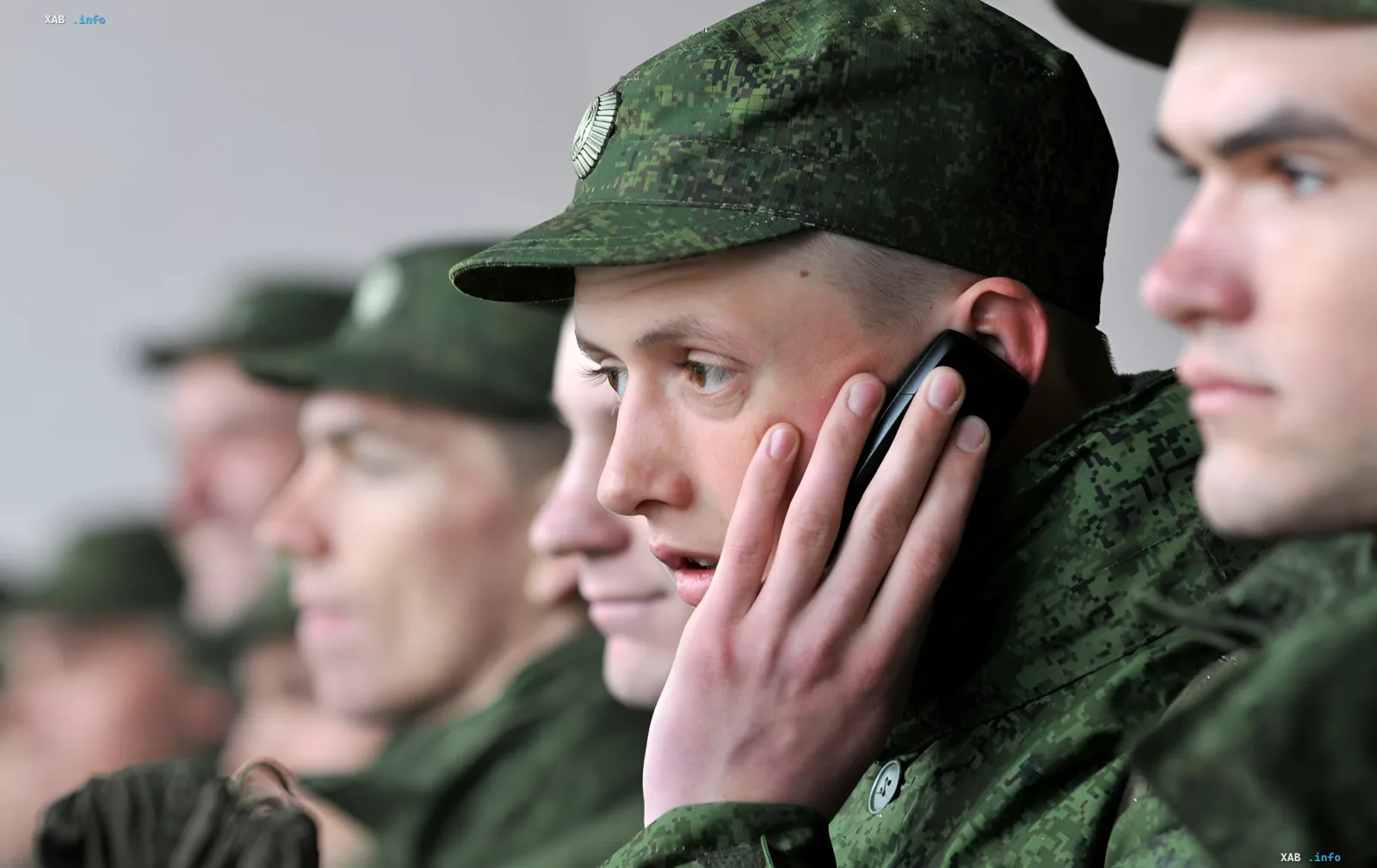 Російські солдати в військовій формі, один з них розмовляє по телефону, ілюструючи тему квот на війну та мобілізації