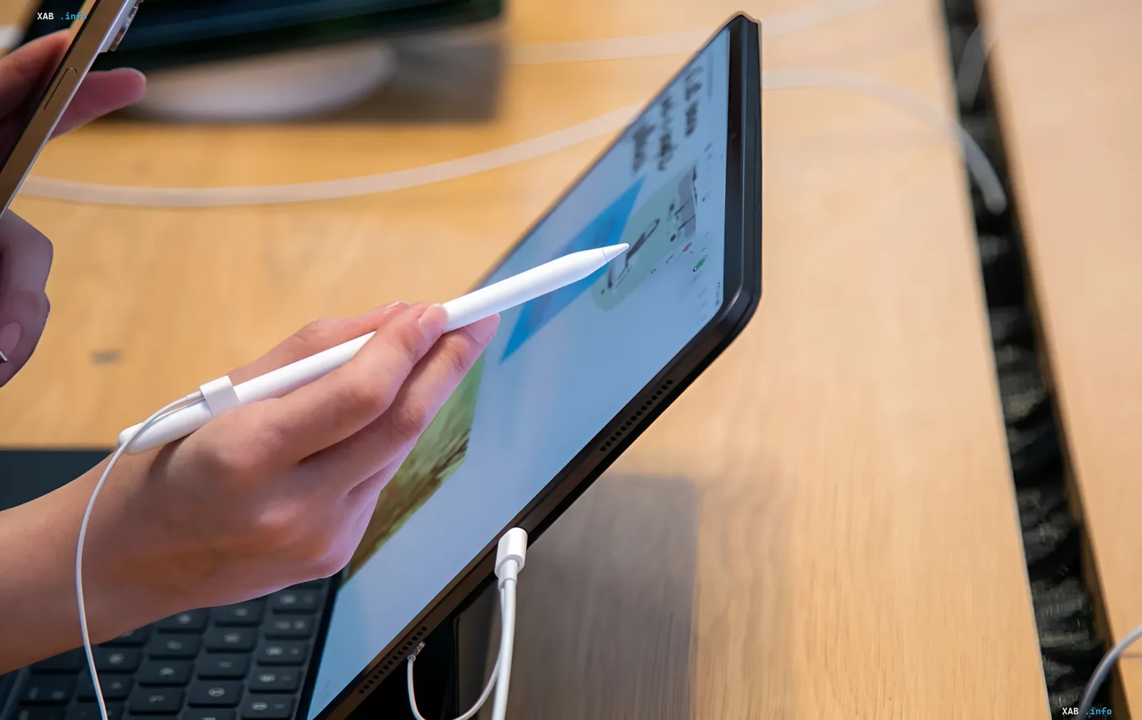 Пользователь использует Apple Pencil с iPad, демонстрируя актуальность темы ремонтопригодности и влияния европейских законов на дизайн гаджетов