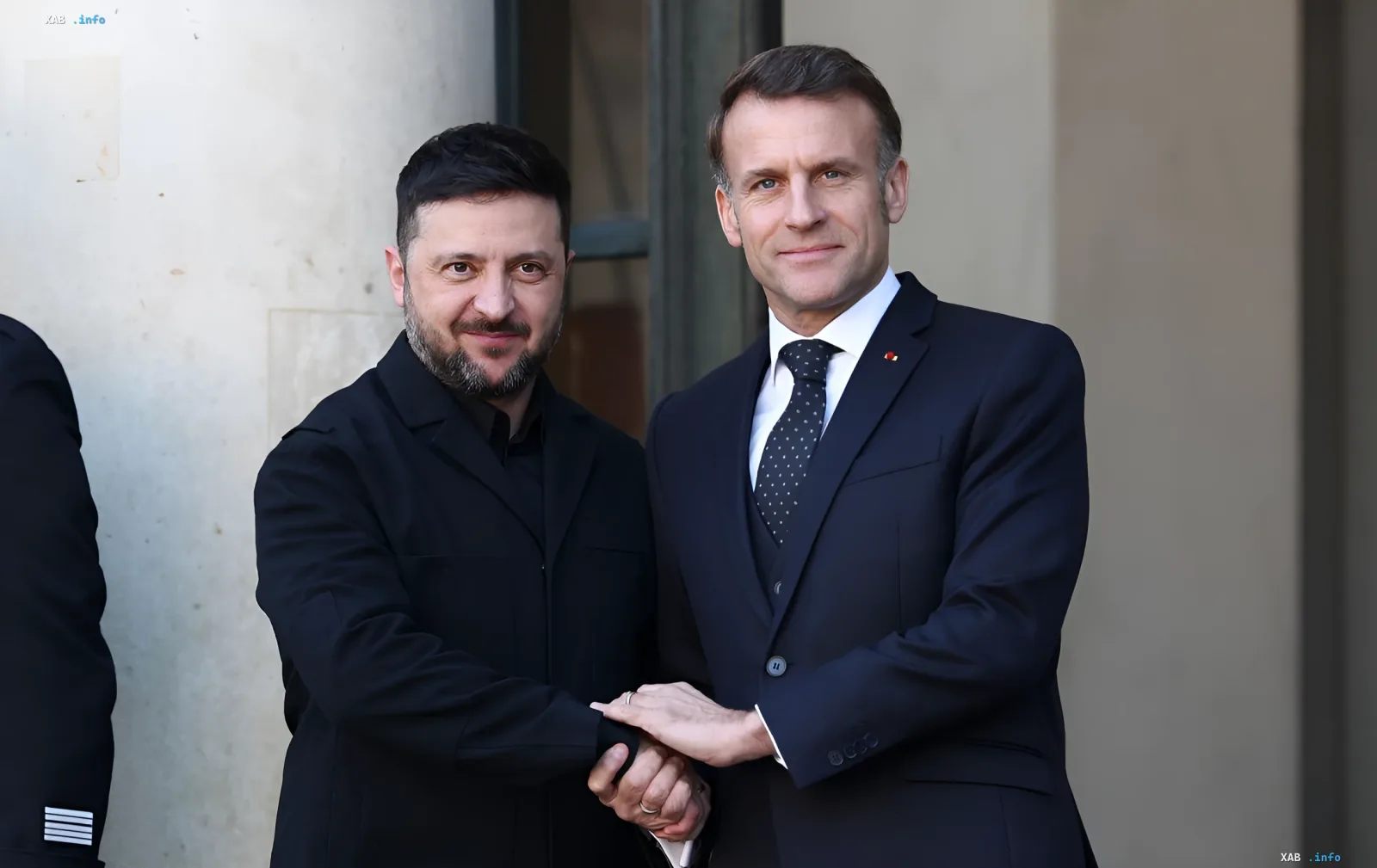 Президент Франції Еммануель Макрон та президент України Володимир Зеленський тримаються за руки на тлі обговорення передачі винищувачів Rafale