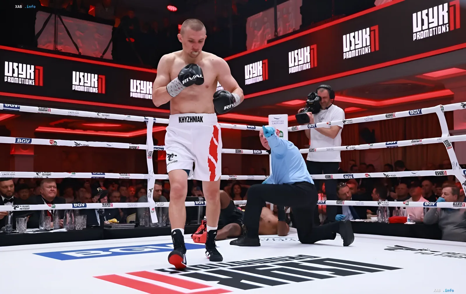 Boxer Alexander Khizhnyak in weißen Shorts mit rotem Muster im Ring während eines Kampfes mit Lenny Patrache, Schiedsrichter zählt