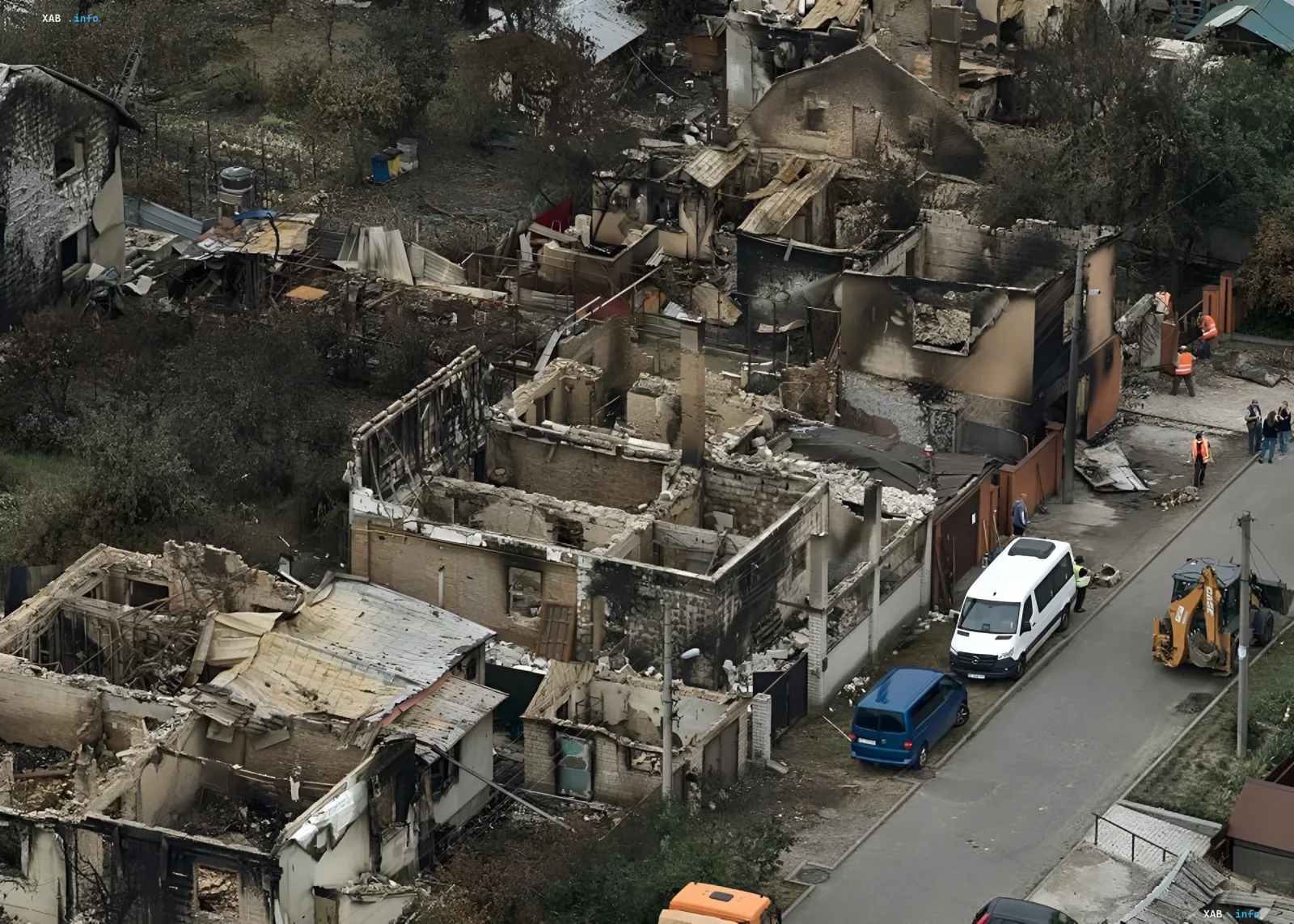 Вид с воздуха на разрушенные пожаром дома в жилом районе, работа спасателей и техники на месте катастрофы