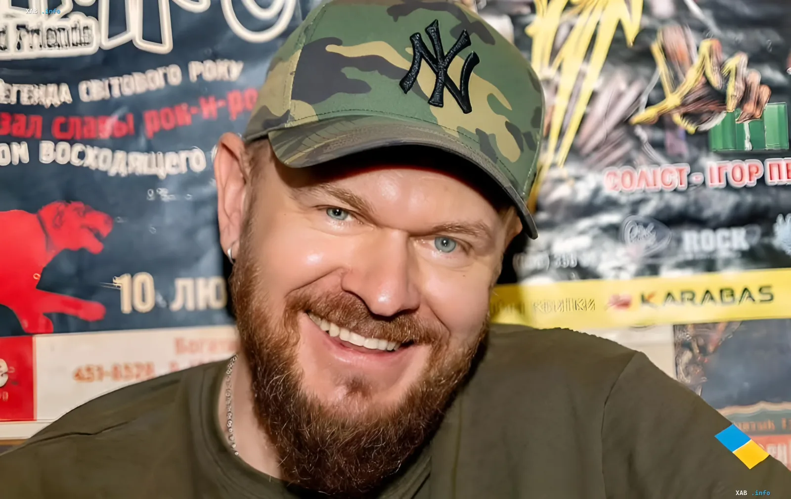 Александр Положинский, фронтмен группы «Тартак», улыбается на фоне музыкальных афиш, обсуждая личную жизнь в условиях войны