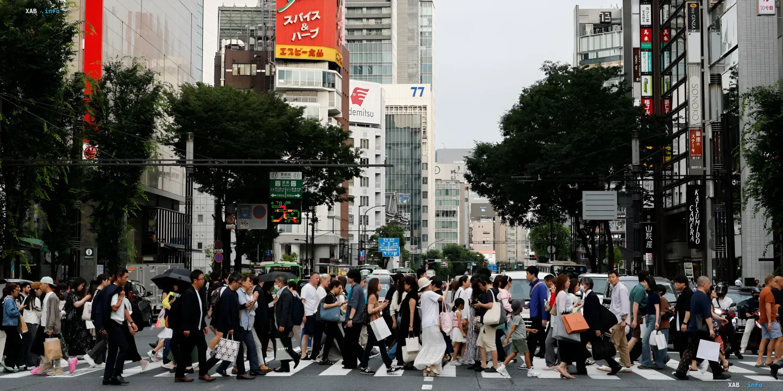 Lebhafter Fußgängerüberweg in Tokio vor Wolkenkratzern und japanischen Schildern, der das Alltagsleben der Hauptstadt vor Spionagebedrohungen symbolisiert