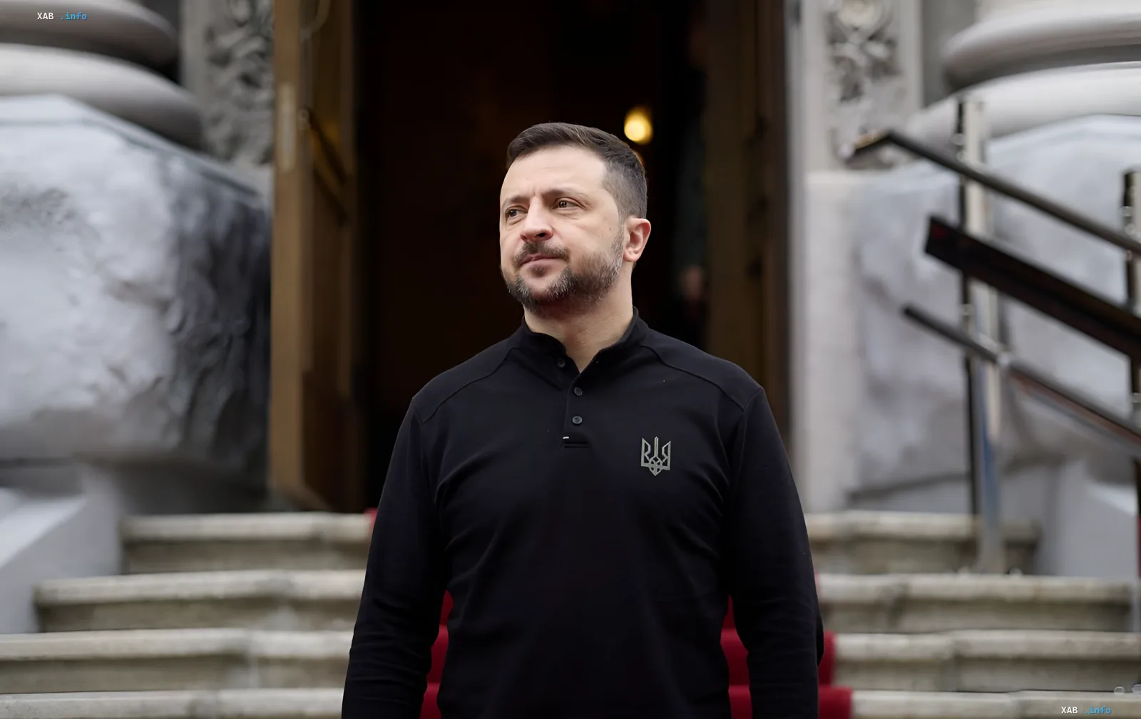Ukrainischer Präsident Wolodymyr Selenskyj in einem schwarzen Hemd mit einem Dreizack-Emblem vor den Stufen eines Gebäudes, was die Bereitschaft zur Diskussion über die neue Regierung symbolisiert