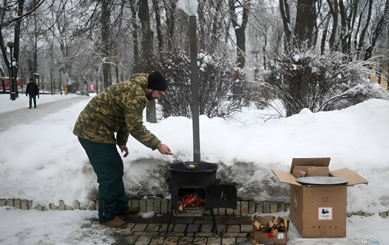 A person cooking food on an outdoor stove in a snowy park, symbolizing heating issues during the winter season