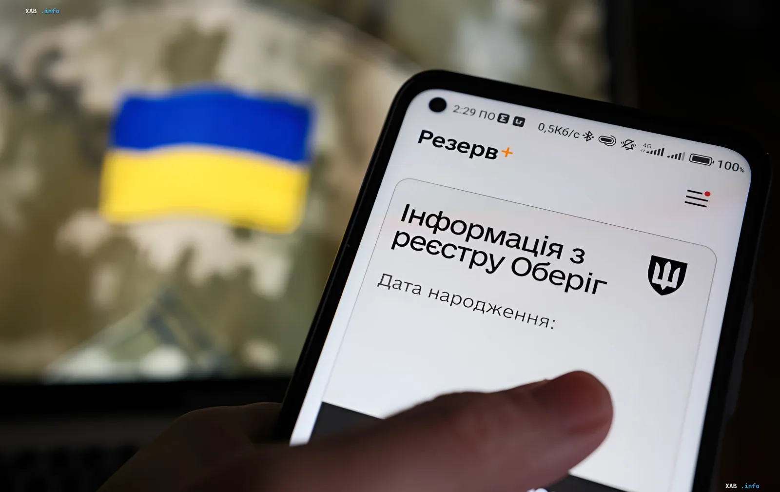 Smartphone mit Reserve+-App und ukrainischer Flagge im Hintergrund — automatische Verlängerung von Mobilmachungs-Aufschüben in der Ukraine