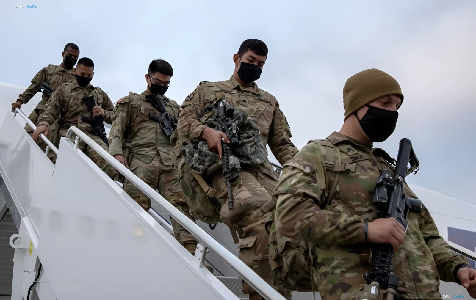 Американские военные в камуфляже и масках спускаются по трапу самолета с оружием, иллюстрируя возможную десантную операцию Пентагона на Кубе