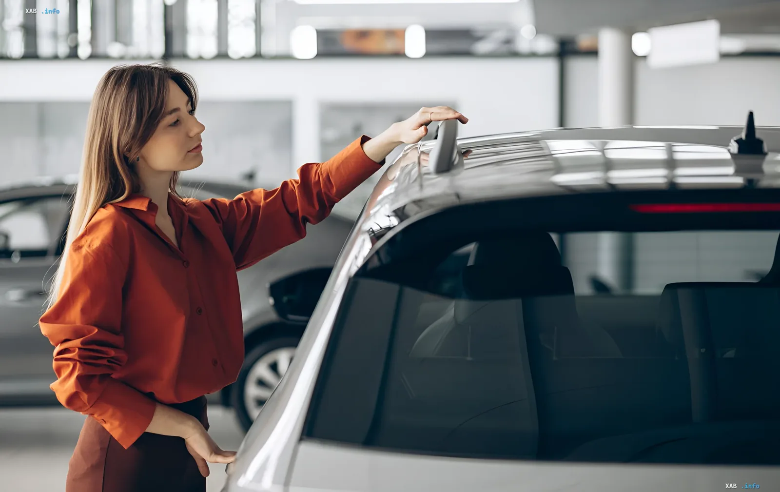Woman inspecting a car in a showroom, illustrating the importance of checking market value when selling a car in Ukraine