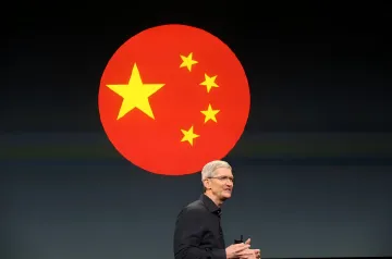 Тим Кук на презентации Apple с флагом Китая на фоне, символизируя стратегическое партнерство Apple Intelligence с Alibaba и Baidu