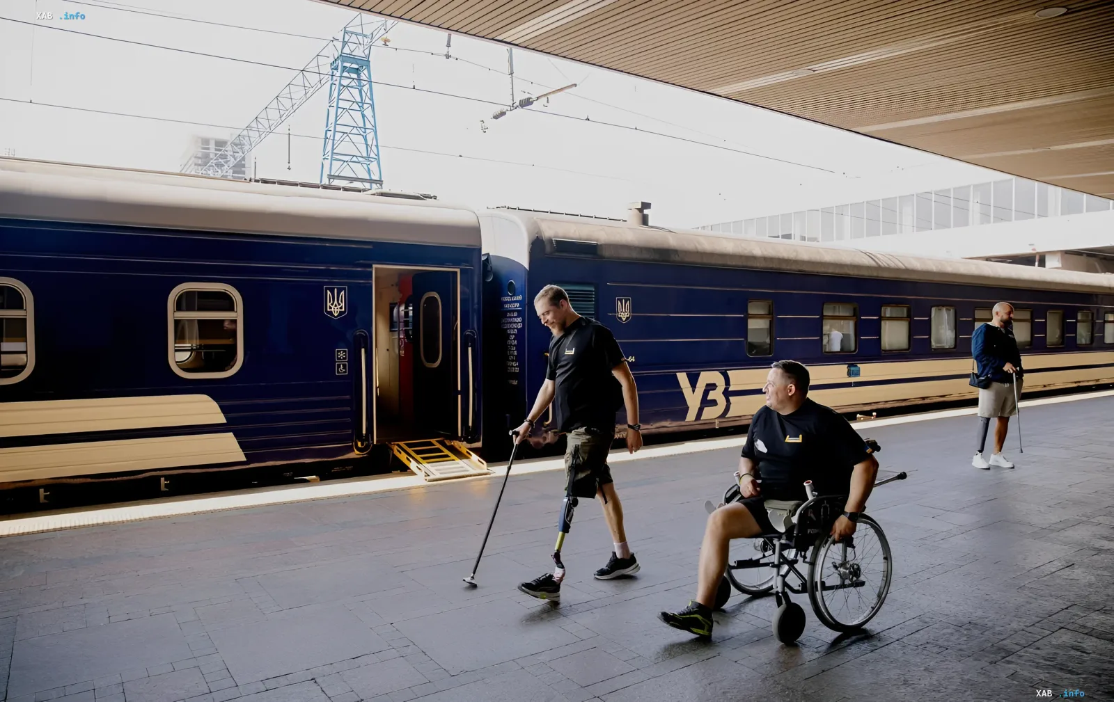 People with disabilities at a train station platform next to a Ukrainian Railways train, illustrating travel benefits