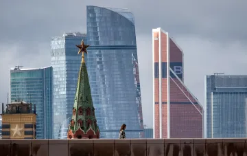 Золота зірка на вежі Кремля на тлі сучасних хмарочосів Москви — символ контрасту між історією та економічними викликами Росії в умовах воєнного дефіциту бюджету до 2029 року