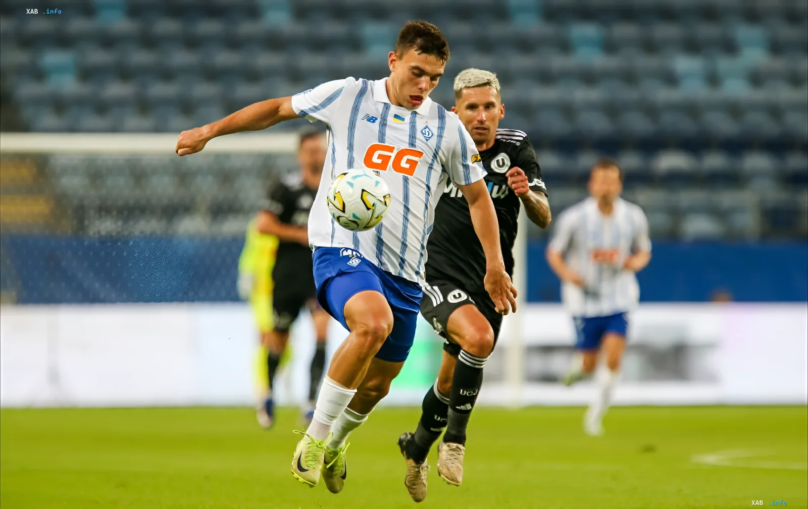 Spieler von Dynamo Kiew im weißen Trikot mit GG-Logo kämpft um den Ball gegen Gegner von Universitatea Craiova im entscheidenden Europa-League-Qualifikationsspiel