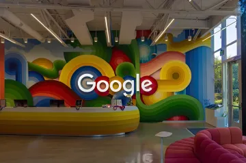 Google-Logo an einer bunten Büro-Wand, das das 25-jährige Jubiläum von Google Bilder und seine Entwicklung von Suchen nach Tags zur KI-generierten Bildwelt symbolisiert