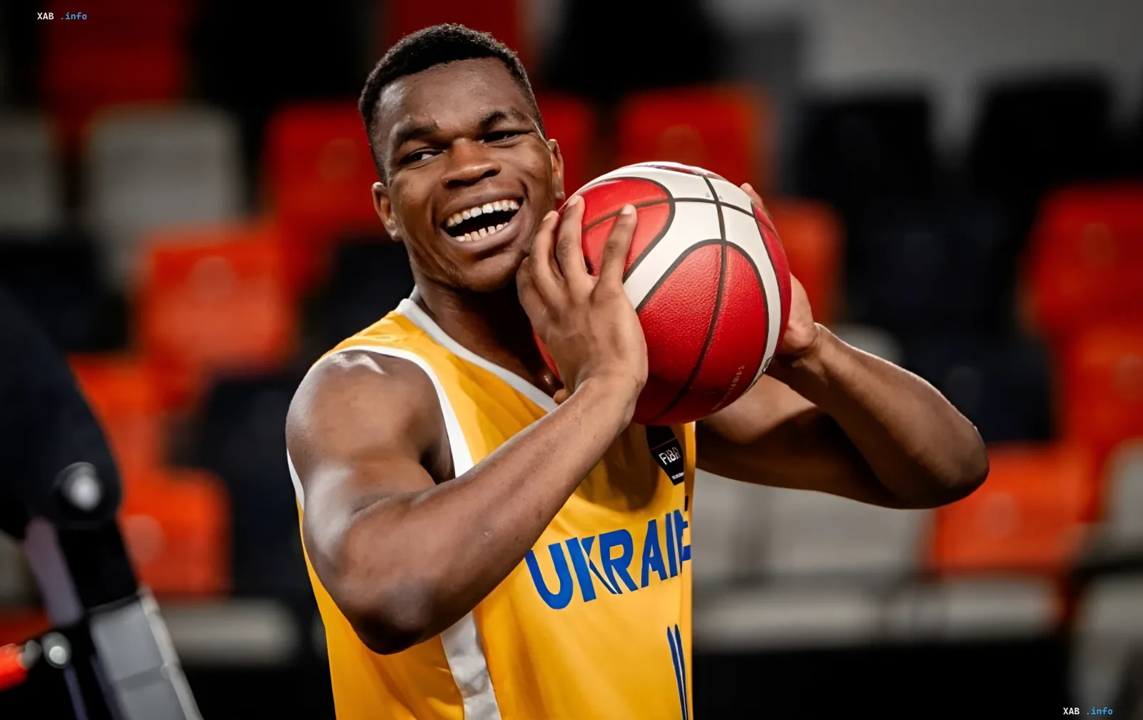 Ukraine U-20 basketball player holding a ball and smiling after advancing to the EuroBasket quarterfinals