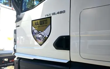 White MAN TGX truck with 'Na Shchiti' emblem and 'Evakuatsiya Poleglykh' inscription — vehicle for repatriation of fallen Ukrainian defenders