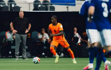 Krisencio Sammeville in the orange jersey of the Netherlands national team controlling the ball on the field