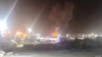 Nighttime missile attack on military bases in the Persian Gulf, explosions and smoke rising over the facility