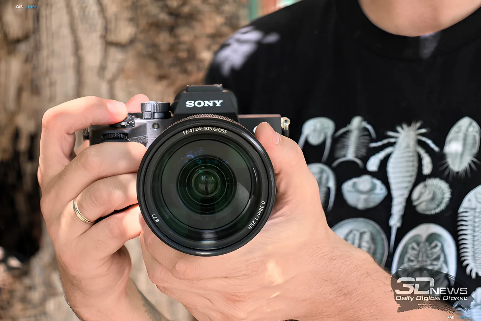 Фотограф держит камеру Sony a7 V с объективом FE 4/24-105 G OSS, демонстрируя эргономику и компактность новой модели