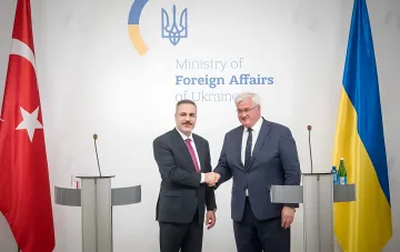 Министр иностранных дел Турции Мевлют Чавушоглу и глава МИД Украины Дмитрий Кулеба пожимают руки на фоне флагов стран в Министерстве иностранных дел Украины