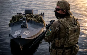 Ukrainischer SBU-Kämpfer neben dem Kampfdrohnen-Katamaran 'Mamai' im Schwarzen Meer, bereit für den Angriff auf russische Tanker