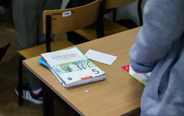 Український школьник на уроці польської мови в Польщі з підручником 'Język Polski' на парті