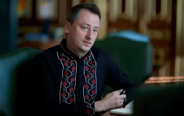 Алексей Соболев в вышиванке за столом с блокнотом и ручкой, готовится к новым задачам в Офисе Президента Украины