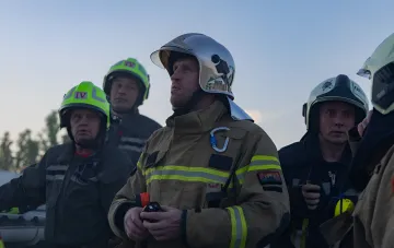 Спасатели в защитной экипировке на месте удара беспилотников по гуманитарному составу ООН в Днепре