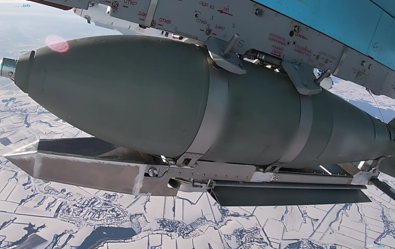 Авиационная бомба на подкрыльевом узле подвески военного самолета над заснеженной местностью