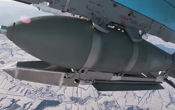 Авиационная бомба на подкрыльевом узле подвески военного самолета над заснеженной местностью