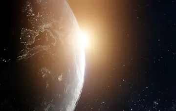 View of Earth from space against a rising Sun — symbol of life’s origin, now questioned by new mathematical research