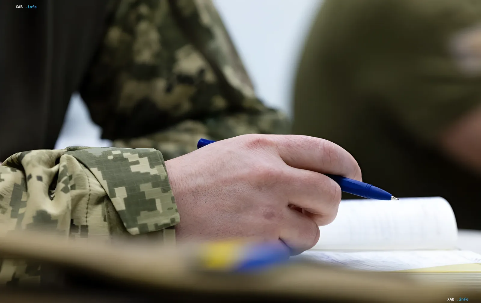 Військовослужбовець у камуфляжі пише в зошиті — символ планування податкових пільг для захисників