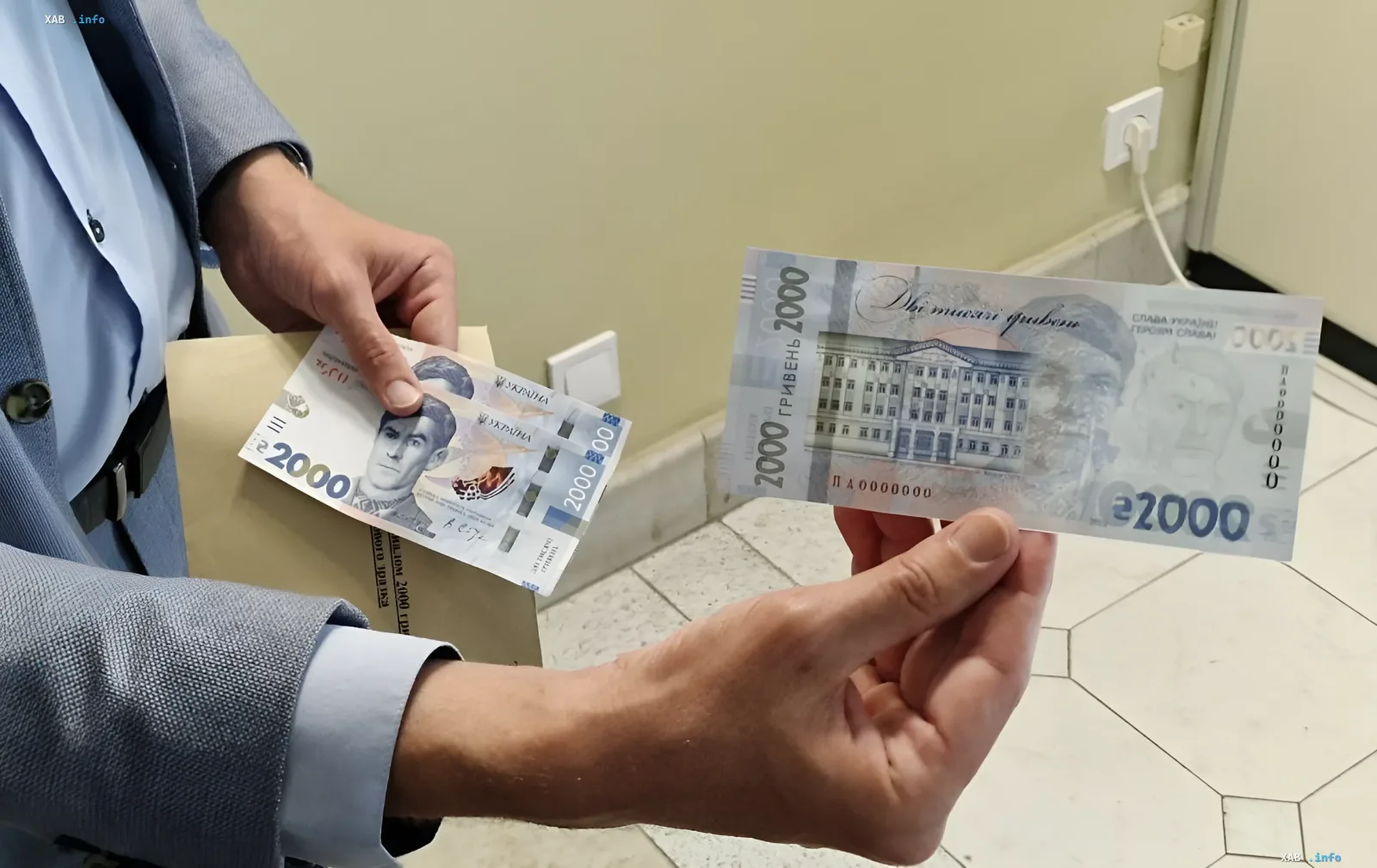 Екс-міністр фінансів України тримає в руках нову купюру номіналом 2000 гривень, ілюструючи критику рішення НБУ щодо введення великих номіналів як кроку проти європейських трендів