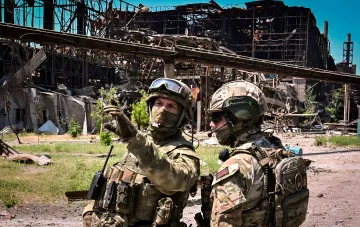 Військові у камуфляжі на тлі зруйнованого промислового об'єкта — ілюстрація до звіту естонської розвідки про зростання втрат РФ та паливний кризис на фронті