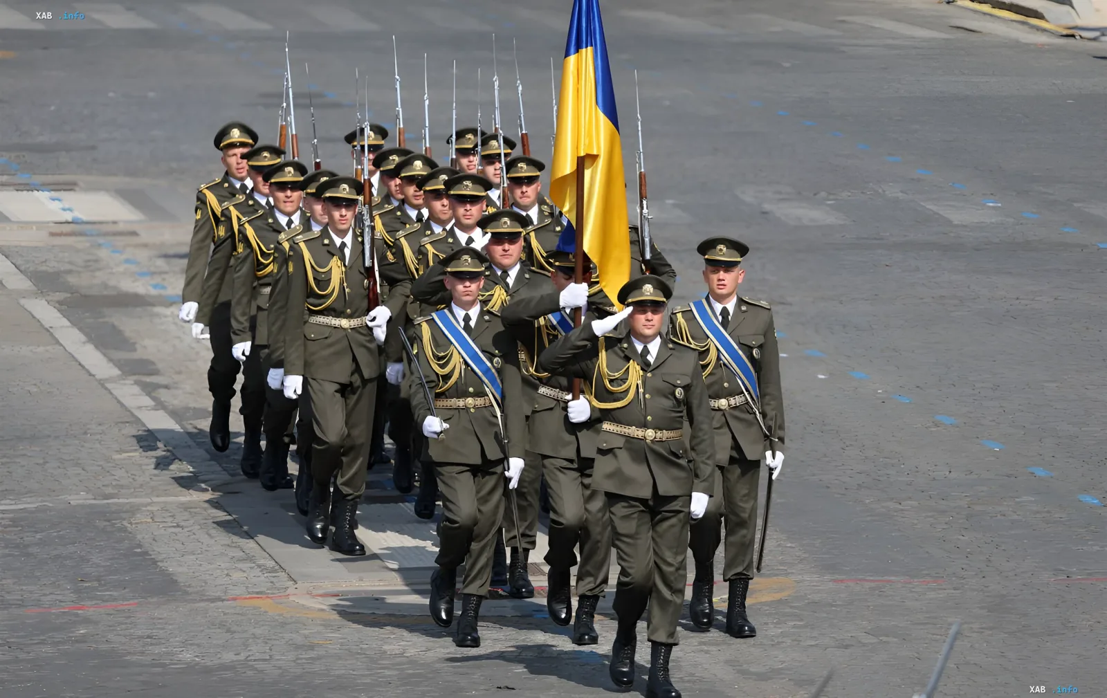 Український почесний караул маршує з прапором України під час військового параду в Брюсселі