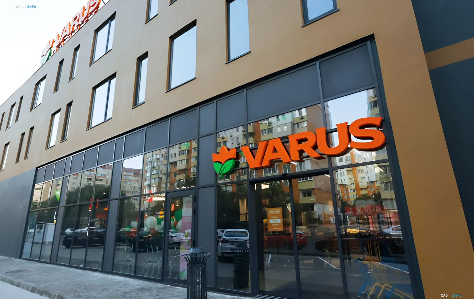 Фасад магазину Varus з помаранчевим логотипом та квіткою, що символізує розширення мережі та поглинання «Коло» в Україні