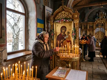 Пожилая женщина зажигает свечи в церкви перед иконой Богородицы, что символизирует молитвенные традиции в Афанасьев день, когда, согласно народным поверьям, нельзя копать землю.